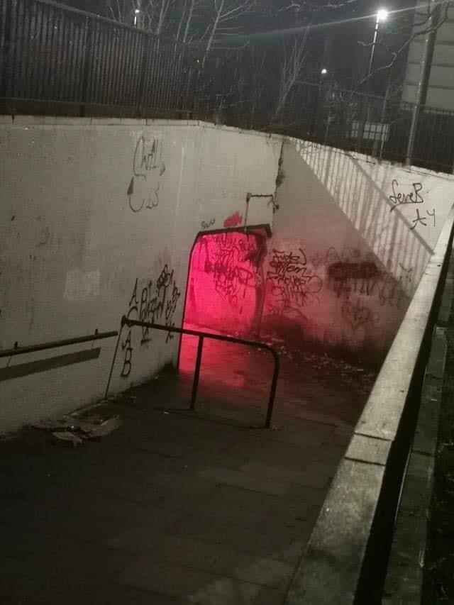 The meme is an image of a dark and abandoned subway tunnel. The text "I love this place" is scribbled on the wall in a childish, messy handwriting. The image is often used to express a sense of irony or sarcasm, implying that the speaker is not actually enjoying the eerie and possibly threatening environment.